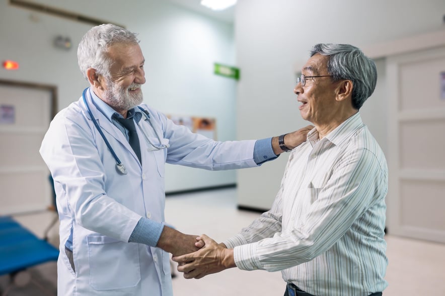 Doctor smiling and shaking hands with a patient, symbolizing gratitude and appreciation in healthcare.