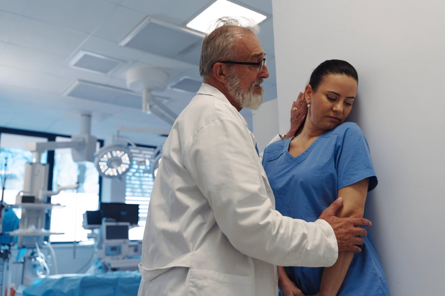 A senior doctor acting inappropriately towards a young female nurse, highlighting workplace abuse or bullying.